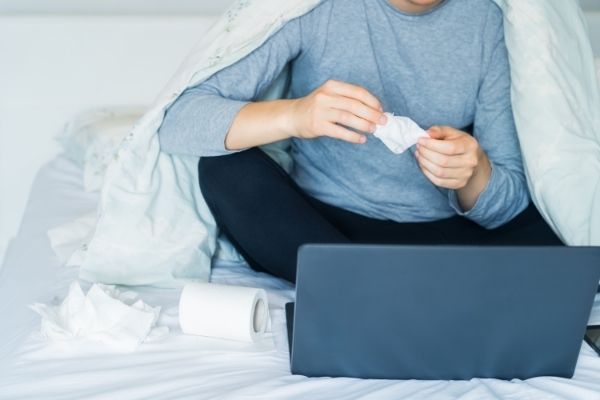 Chorý chlap v posteli s počítačom